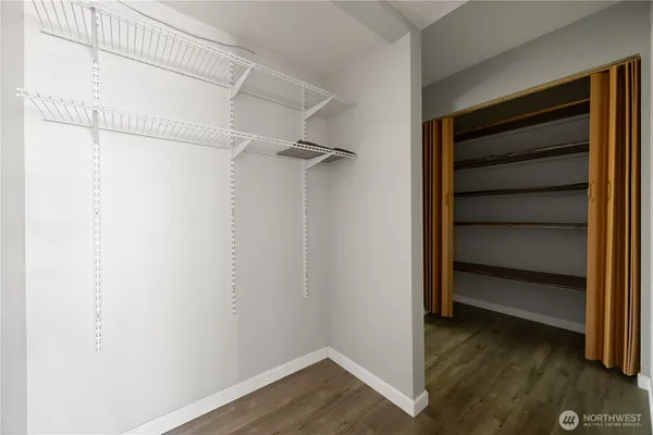 a view of a hallway with wooden floor and windows