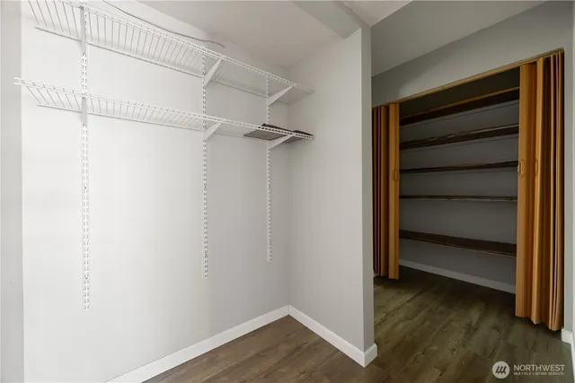 a view of a hallway with wooden floor and windows