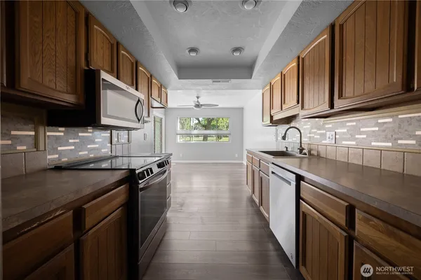 a kitchen with stainless steel appliances granite countertop a sink stove and cabinets