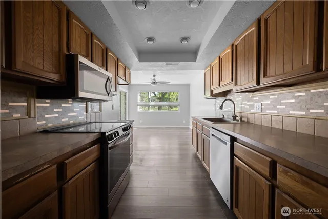 a kitchen with stainless steel appliances granite countertop a sink stove and cabinets