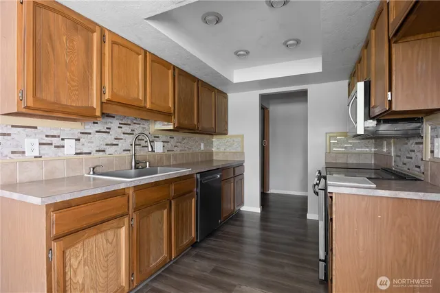 an empty room with wooden floor ceiling fan and windows