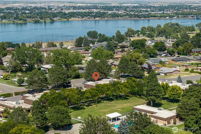 an aerial view of residential houses with outdoor space and lake view