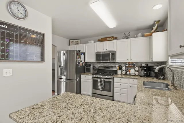 a kitchen with stainless steel appliances granite countertop a stove a refrigerator and a refrigerator