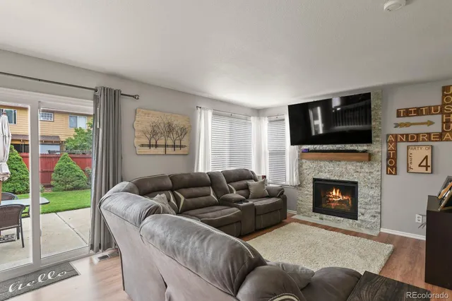 a living room with furniture a fireplace and a flat screen tv