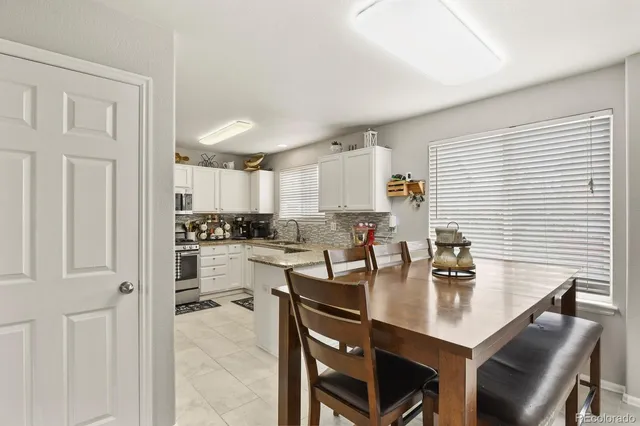 a kitchen with a table chairs and white cabinets