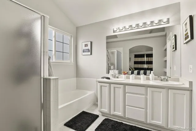 a bathroom with a tub sink and mirror