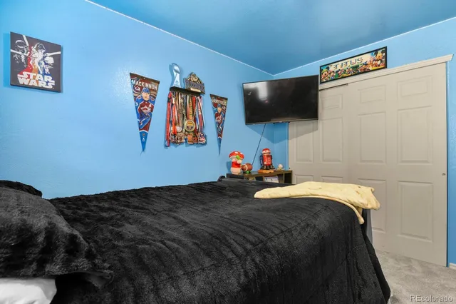 a bed sitting in a bedroom and tv