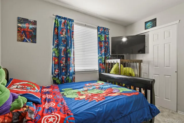 a bedroom with a bed and a painting on the wall