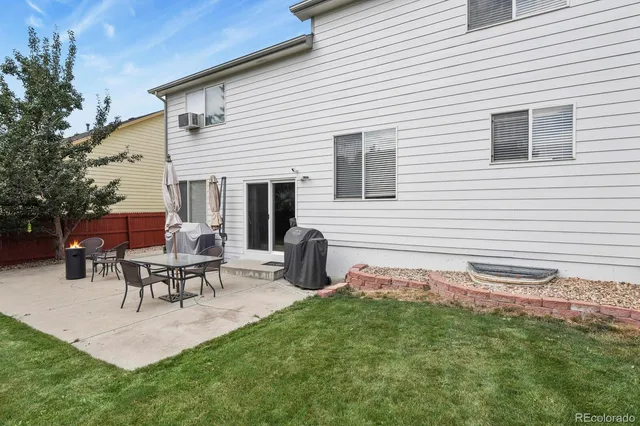 a view of a patio with table and chairs and wooden fence