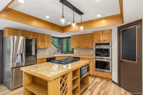 a kitchen with stainless steel appliances granite countertop a stove and a refrigerator