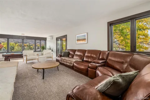 a living room with furniture and a floor to ceiling window