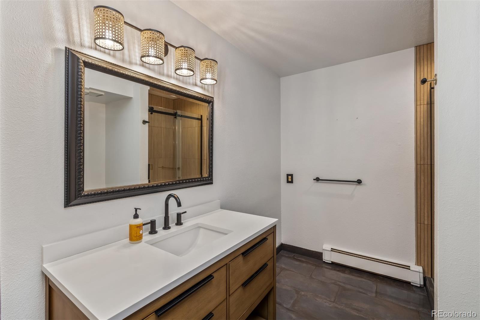 6 Blue Grouse Ridge Road Littleton, CO 80127 - Photo 43 of 50 a bathroom with a sink a mirror and vanity