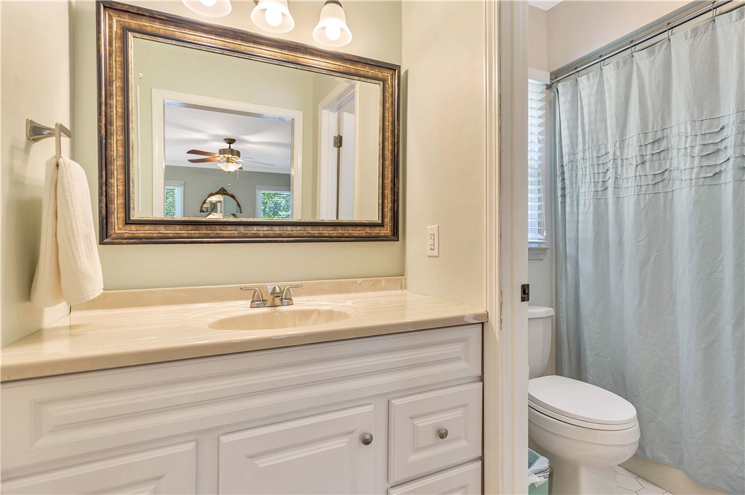 910 Chantilly Lane Anderson, SC 29625 - Photo 12 of 38 A refined bathroom featuring a spacious vanity with an elegant framed mirror and an adjacent shower.