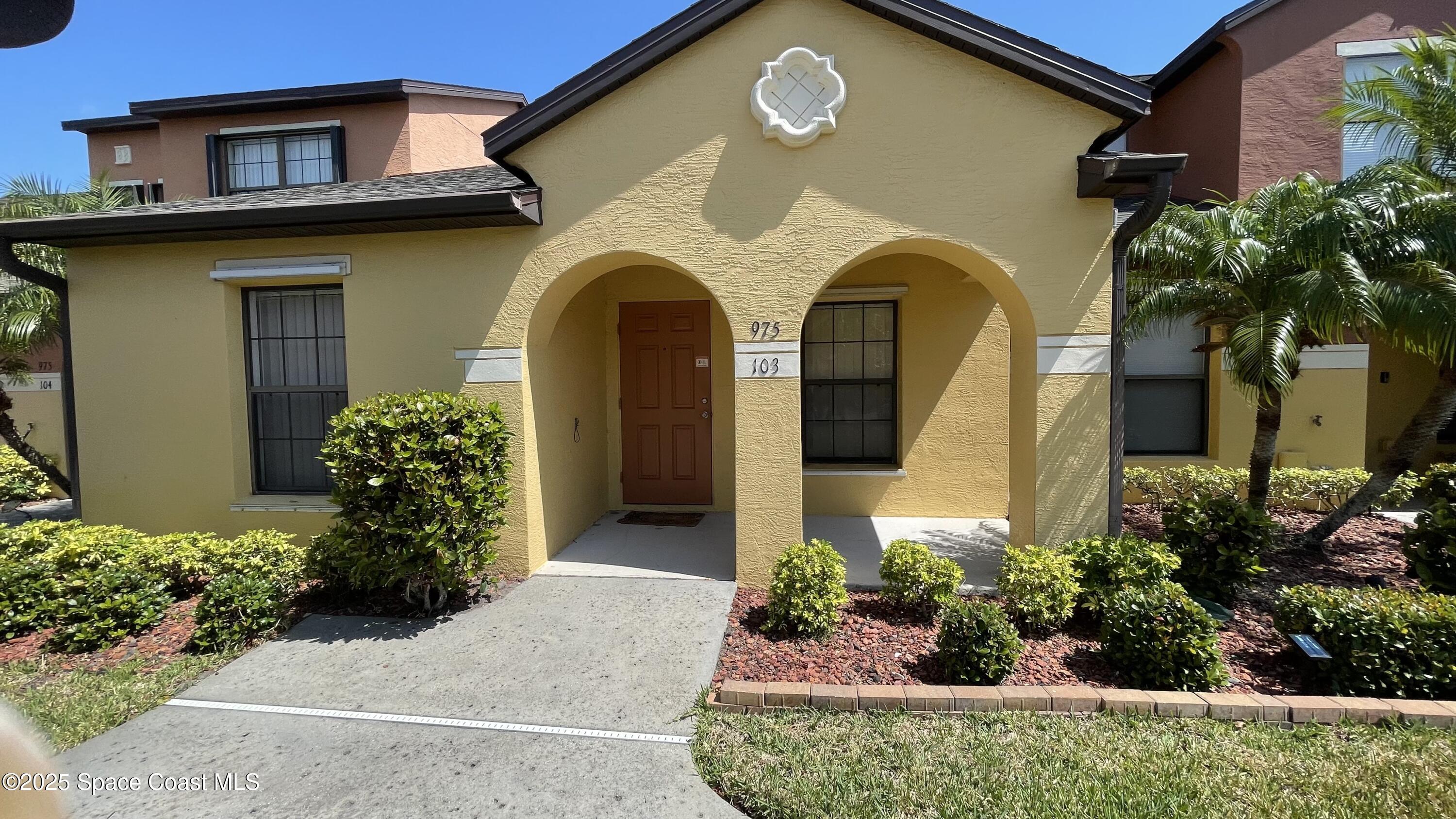 975 Luminary Circle, Unit 103 Melbourne, FL 32901 - Photo 1 of 70 a front view of a house with lots of potted plants
