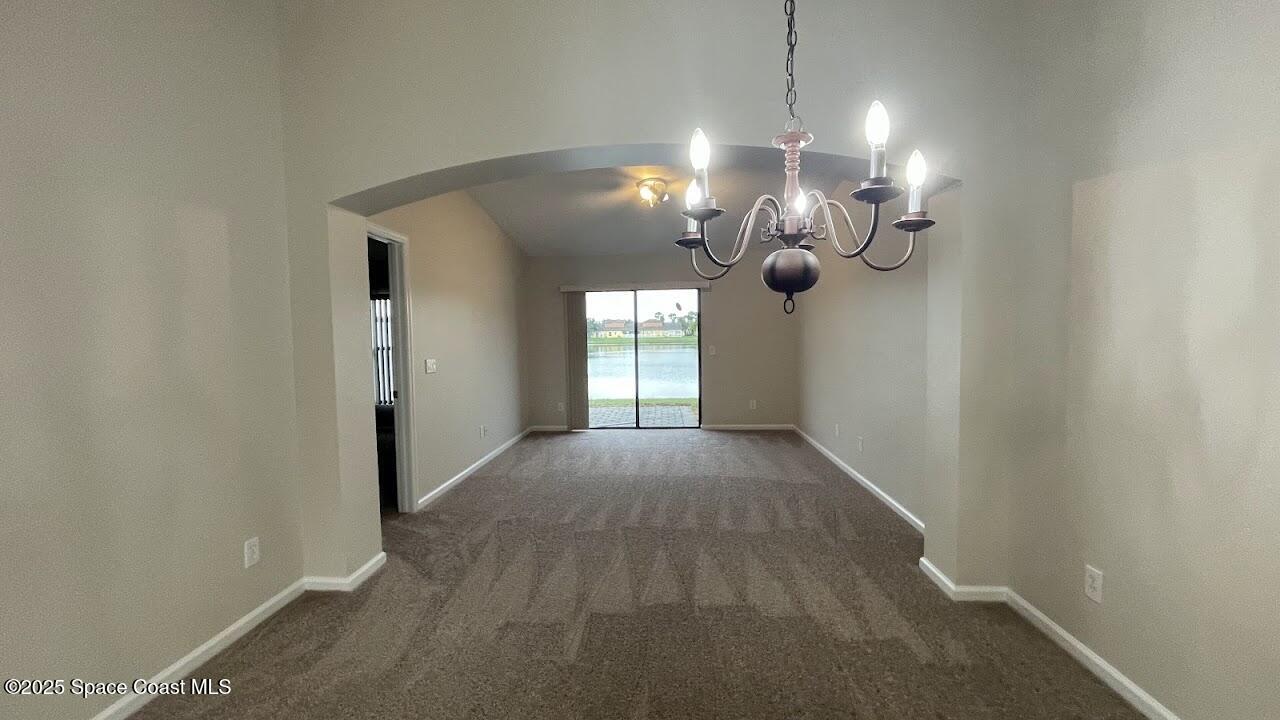 975 Luminary Circle, Unit 103 Melbourne, FL 32901 - Photo 12 of 70 a view of a room with wooden floor and chandelier