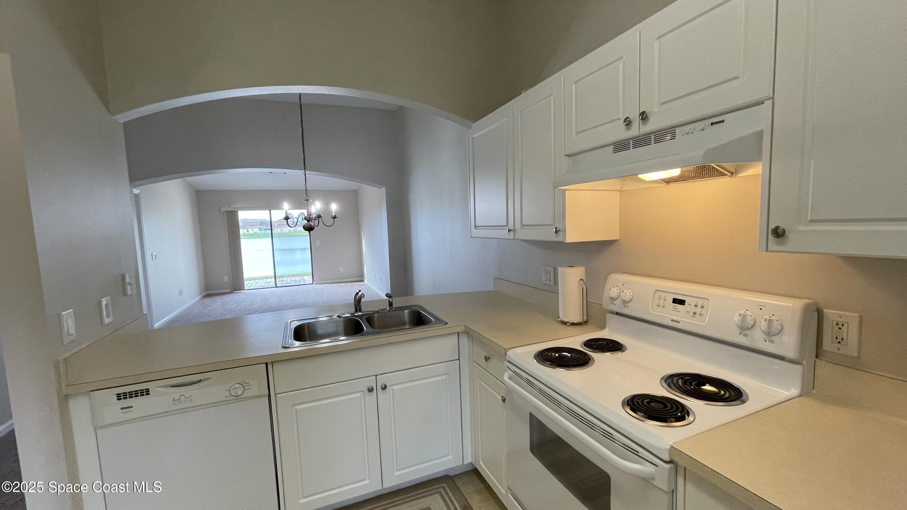 975 Luminary Circle, Unit 103 Melbourne, FL 32901 - Photo 24 of 70 a kitchen with a sink a stove and cabinets