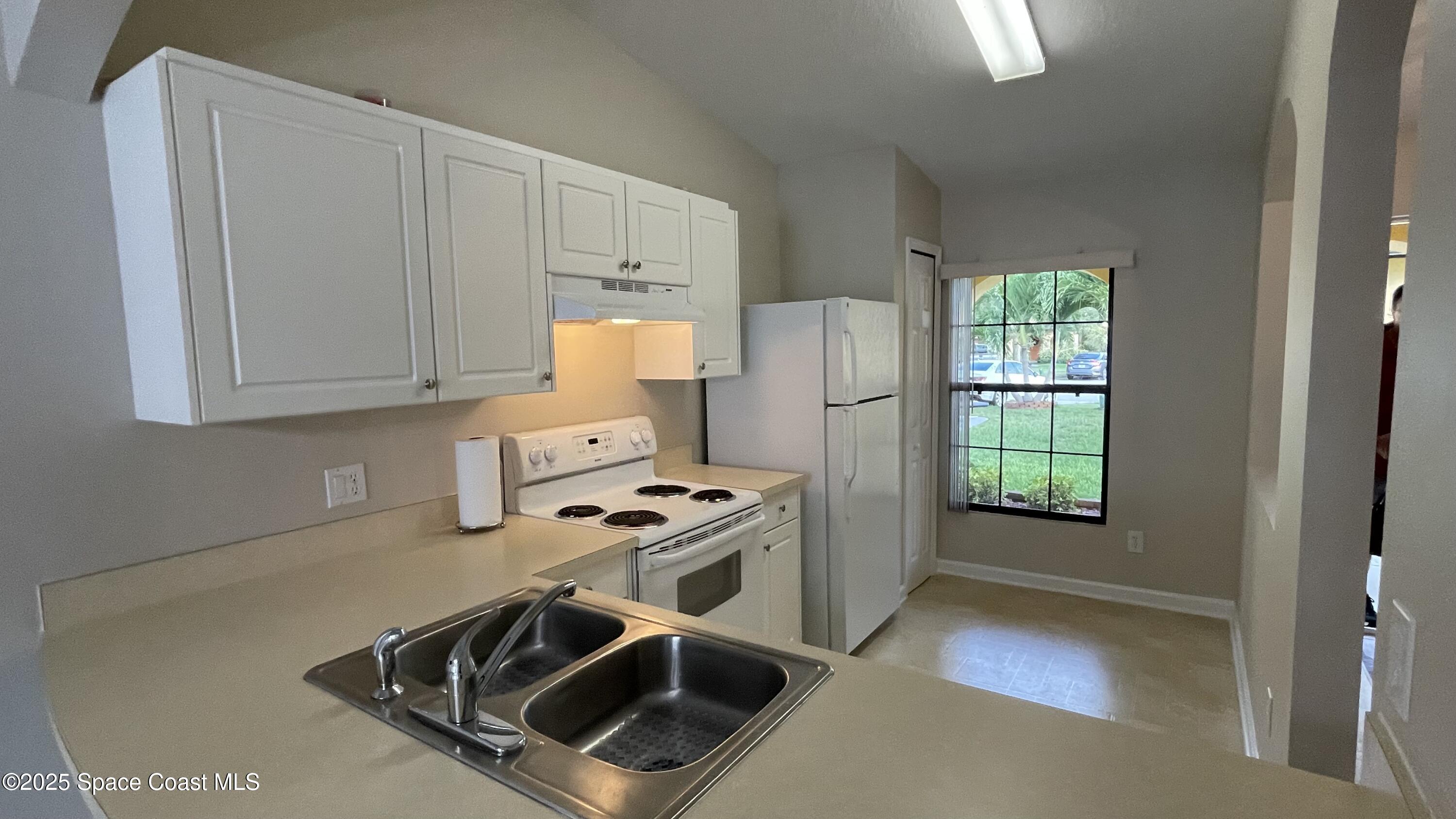 975 Luminary Circle, Unit 103 Melbourne, FL 32901 - Photo 27 of 70 a kitchen with a stove and a microwave