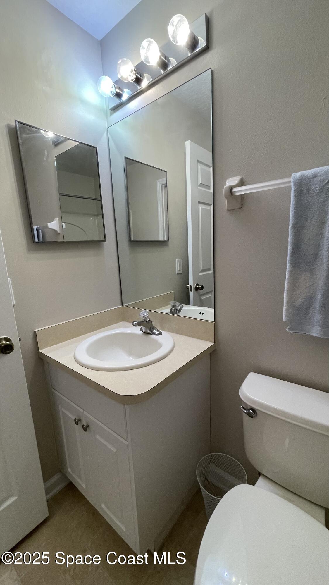 975 Luminary Circle, Unit 103 Melbourne, FL 32901 - Photo 34 of 70 a bathroom with a toilet sink and mirror