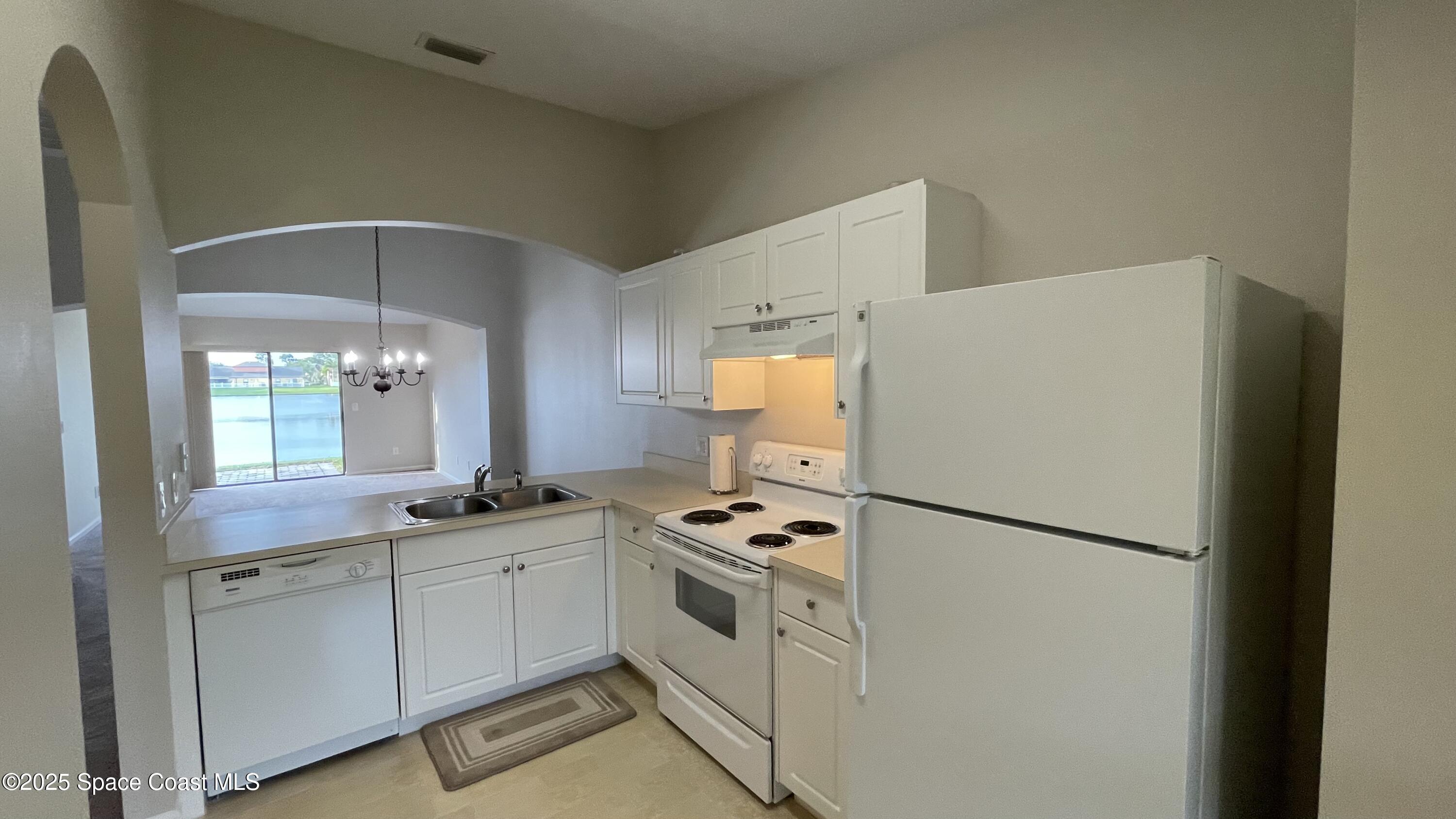 975 Luminary Circle, Unit 103 Melbourne, FL 32901 - Photo 9 of 70 a kitchen with white cabinets and white appliances