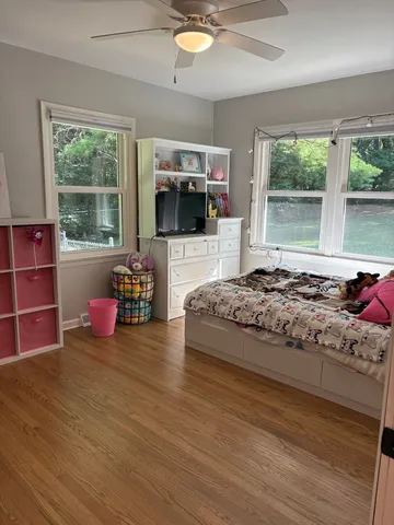 a bedroom with a bed a flat screen tv and windows