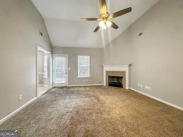 a view of an empty room with a fireplace and a window