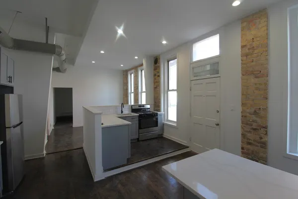a open kitchen with white cabinets and stainless steel appliances