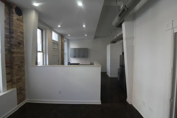 a view of kitchen with refrigerator and window