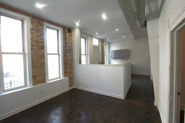 a view of hallway with kitchen and wooden floor