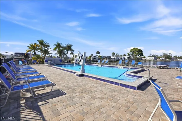 a view of a swimming pool with a lawn chairs under an umbrella