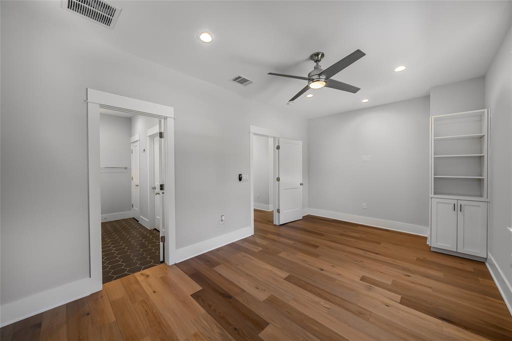 2821 Castro Street, Unit 1 Austin, TX 78702 - Photo 12 of 21 Spacious room featuring wood-finish flooring, a contemporary ceiling fan, recessed lighting, and a built-in shelving unit with lower cabinetry