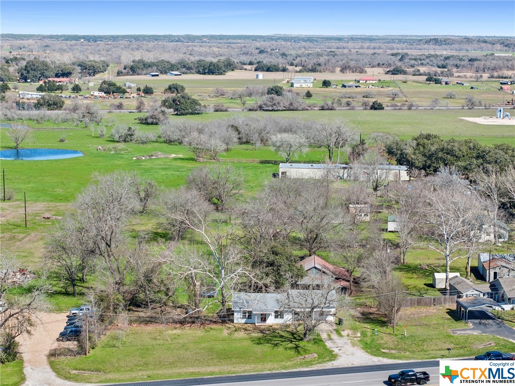 an aerial view of a houses with a yard and lake view