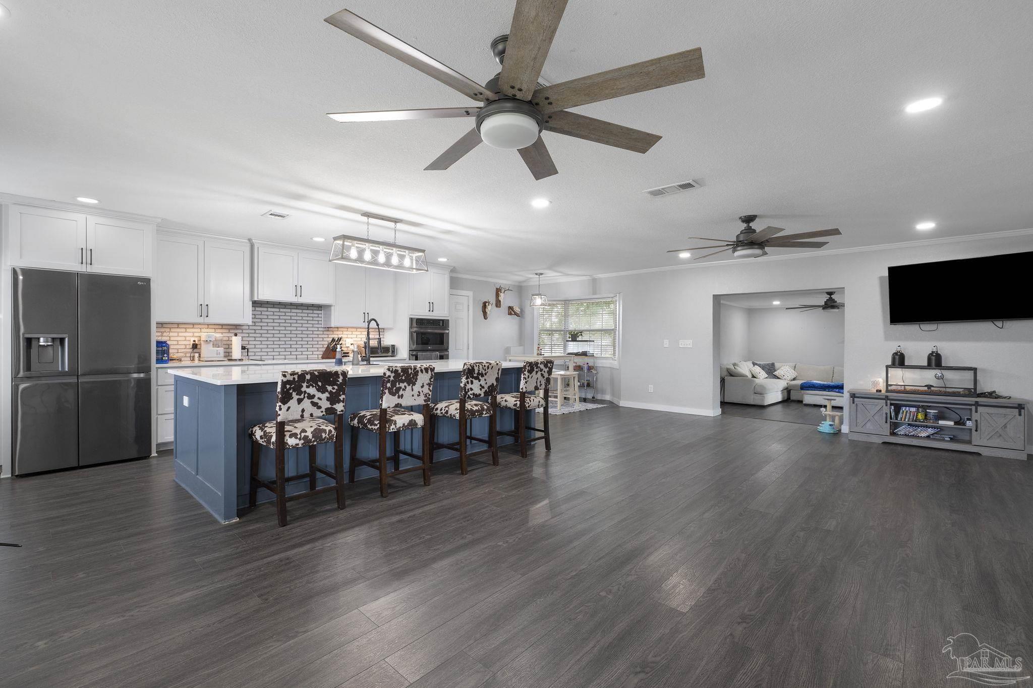 2065 Brownsdale Loop Road Jay, FL 32565 - Photo 2 of 25 a open kitchen with stainless steel appliances granite countertop a refrigerator dining table and chairs with wooden floor