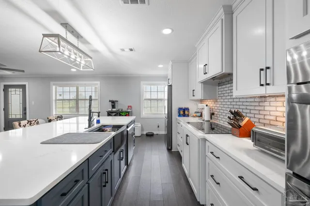 a kitchen with a sink stove cabinets and wooden floor