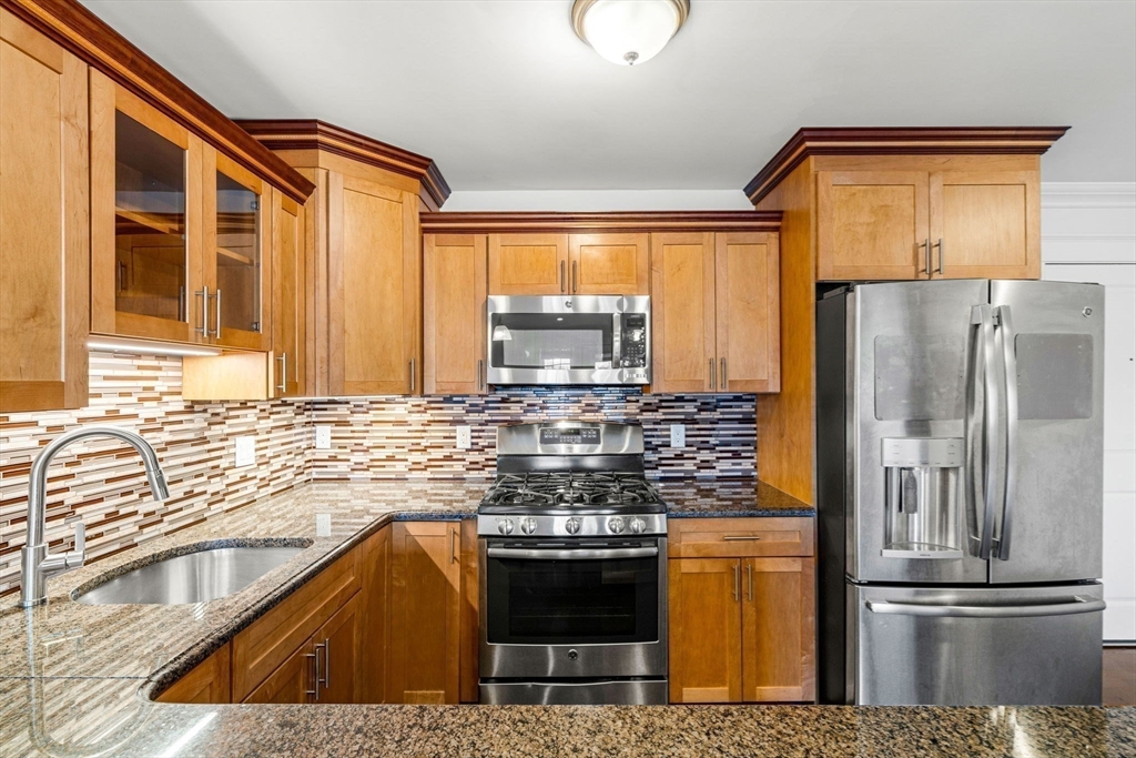 39 Fayette Street, Unit 403 Quincy, MA 02171 - Photo 5 of 24 a kitchen with stainless steel appliances granite countertop a refrigerator and a sink