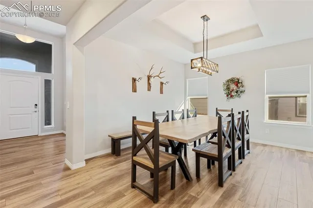 a dining room with furniture a chandelier and wooden floor