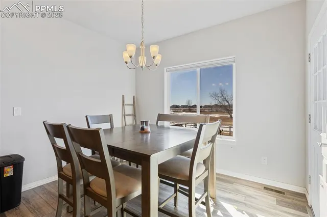 a view of a dining room with furniture a chandelier and wooden floor