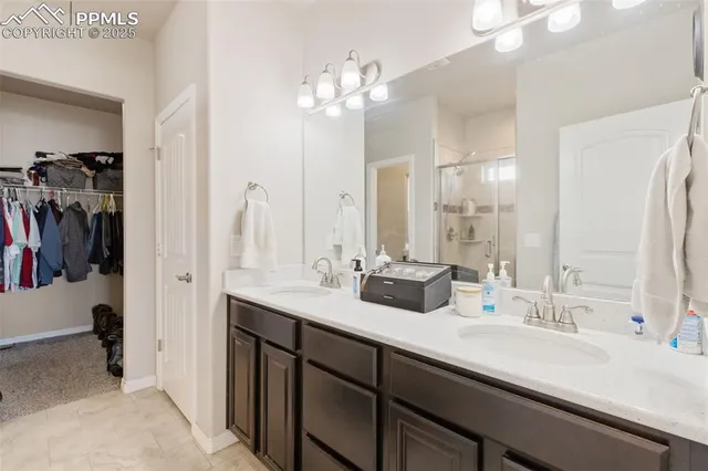 a bathroom with double vanity sinks a vanity a mirror and shower