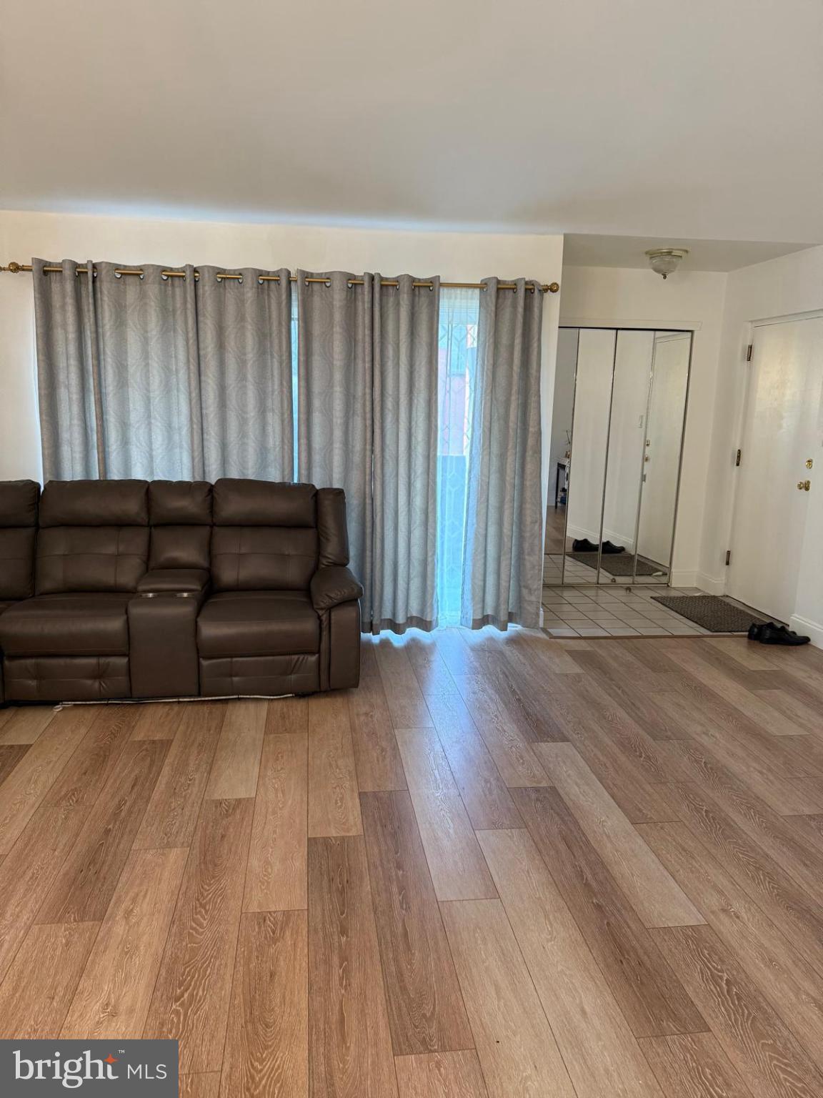 2015 Welsh Road, Unit D50 Philadelphia, PA 19115 - Photo 3 of 4 a living room with couches and kitchen view with wooden floor