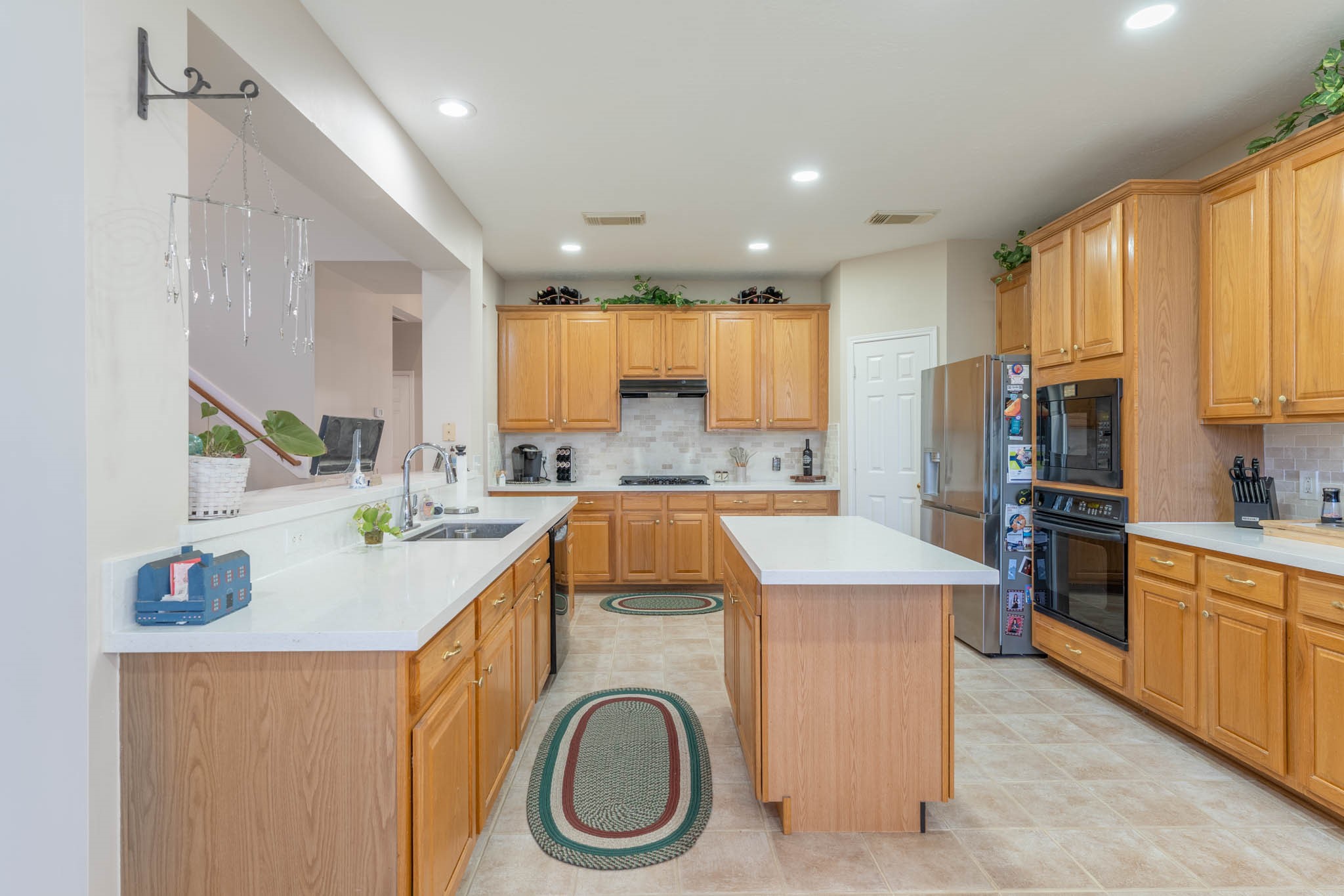 1205 Cambridge Court Seabrook, TX 77586 - Photo 21 of 47 a kitchen with kitchen island a sink a stove a refrigerator cabinets and a window