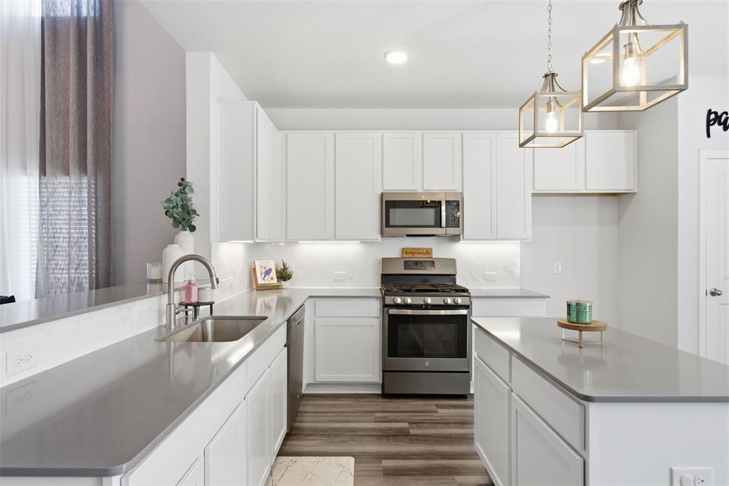 2049 Hartley Drive Forney, TX 75126 - Photo 11 of 36 a kitchen with kitchen island granite countertop a sink stainless steel appliances and cabinets