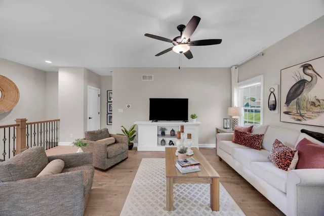 a living room with furniture a rug and a flat screen tv