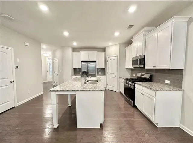 a kitchen with stainless steel appliances granite countertop a sink stove and refrigerator