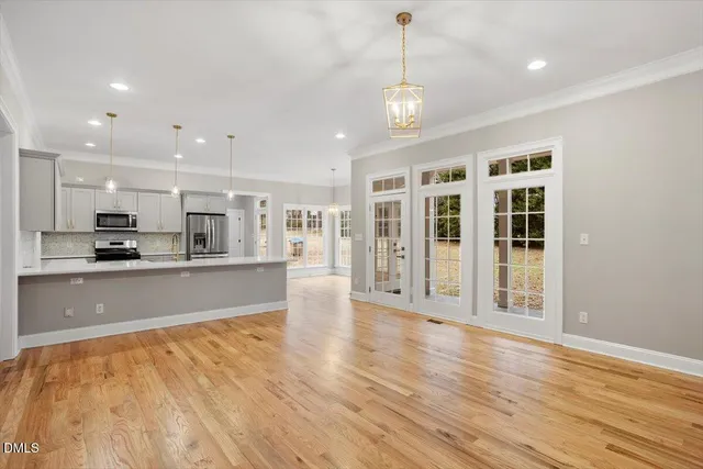 a view of large kitchen with large windows and wooden floor