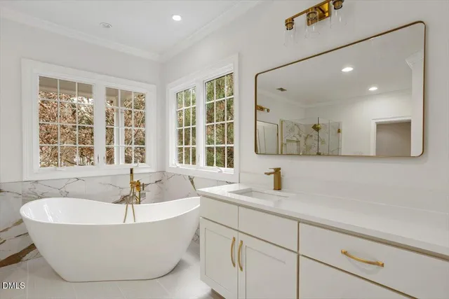a bathroom with a tub a sink and a window