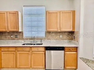 a kitchen with stainless steel appliances granite countertop white cabinets sink and a granite counter top