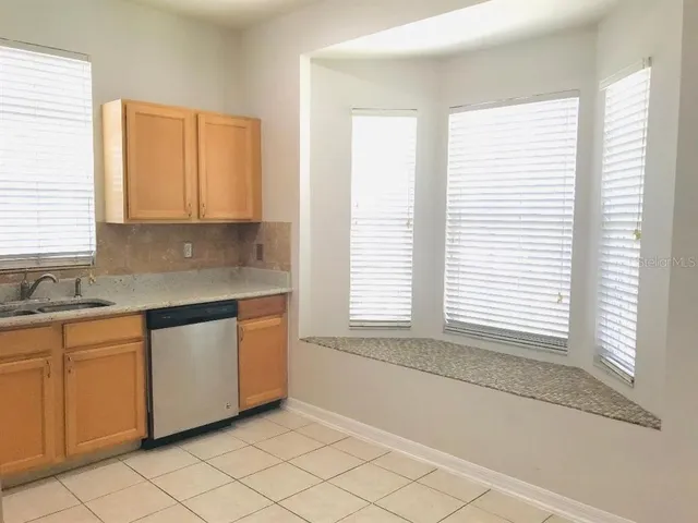 a kitchen with stainless steel appliances granite countertop a sink and a white cabinets