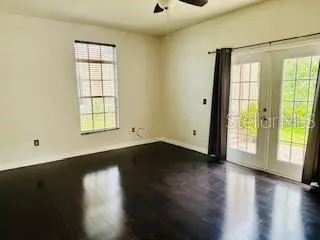 a view of an empty room with wooden floor and a window