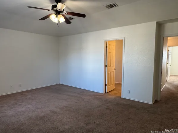 an empty room with a window and a fan