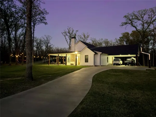 an aerial view of a house with a garden and lake view