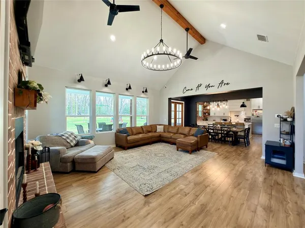 a living room with furniture ceiling fan and a large window